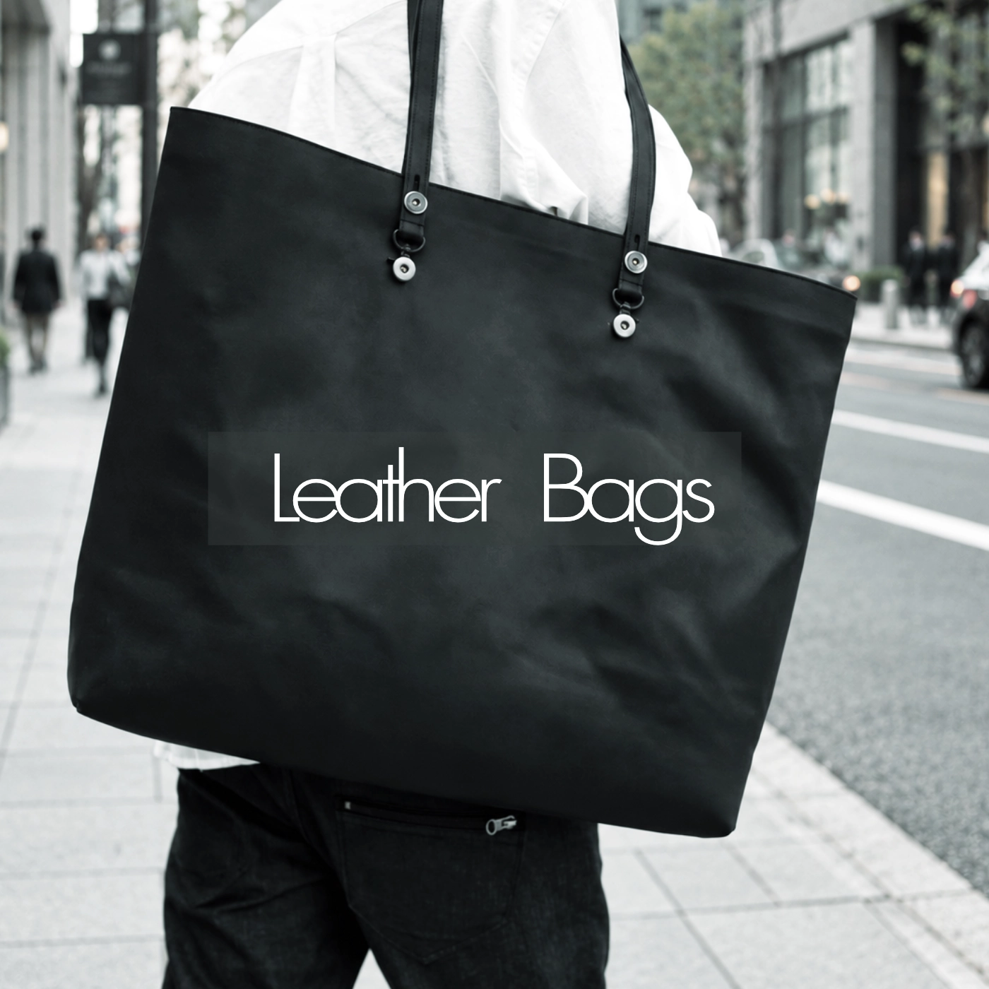 A black leather tote bag carried over the shoulder